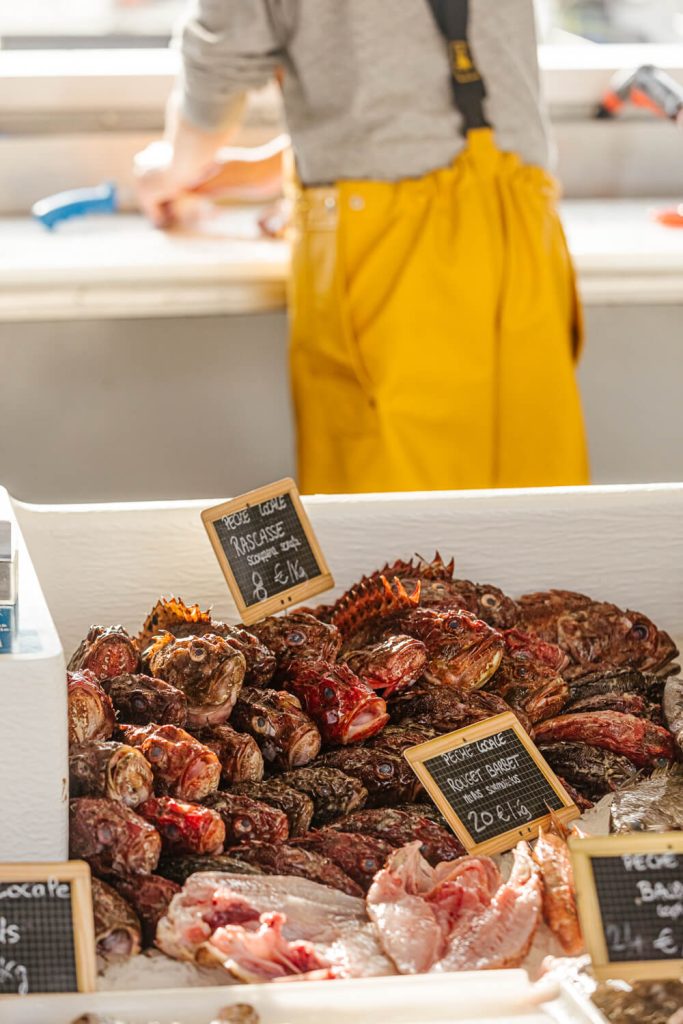 Un pescador prepara pescado en un puesto del mercado de pescado de Capbreton