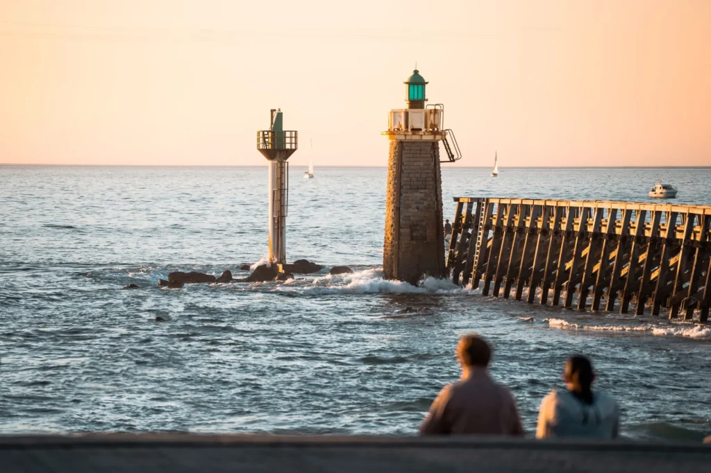Un couple contemple l'Estacade de Capbreton en fin de journée
