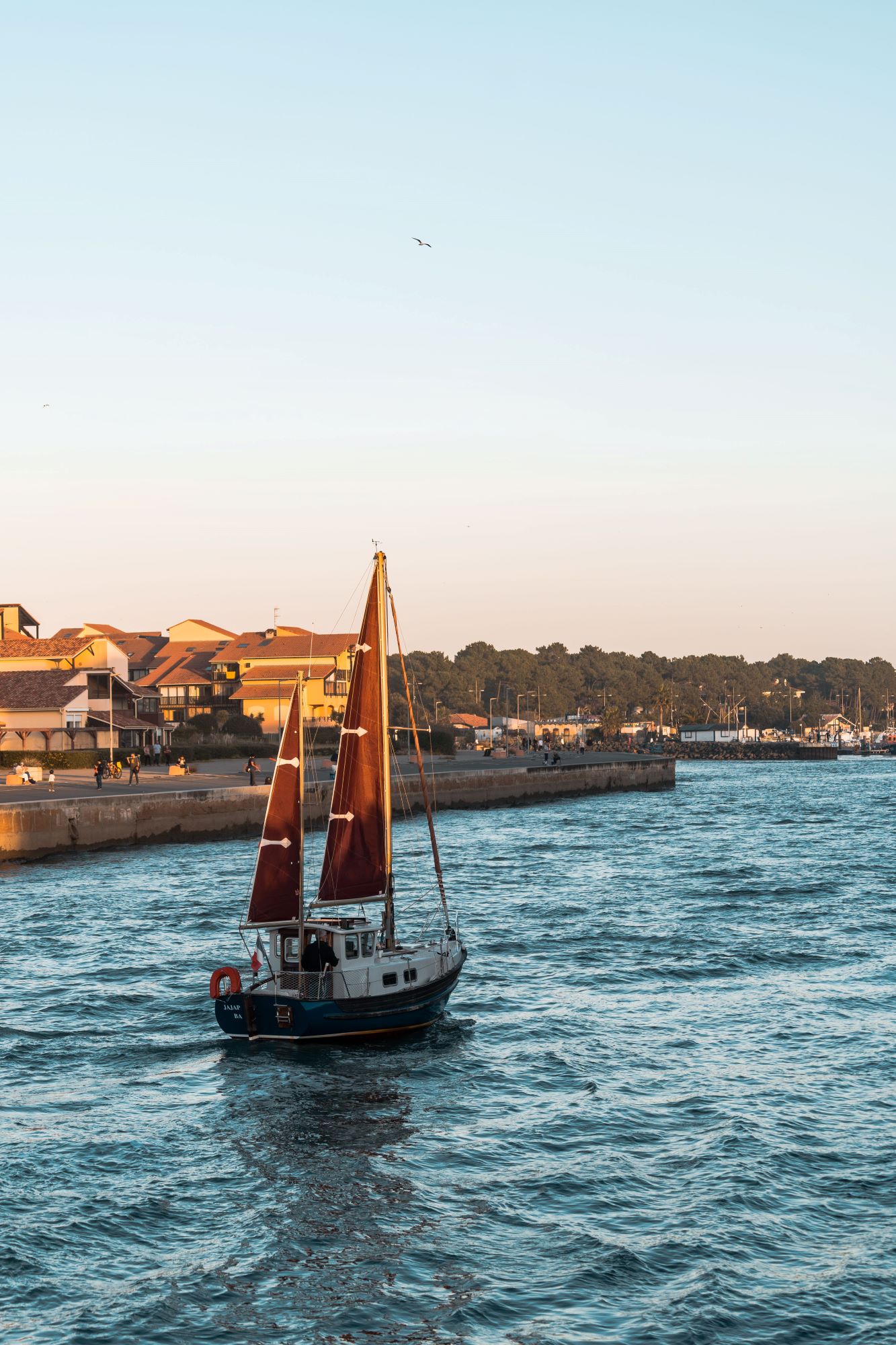 Un voilier rentre au port de Capbreton au coucher de soleil