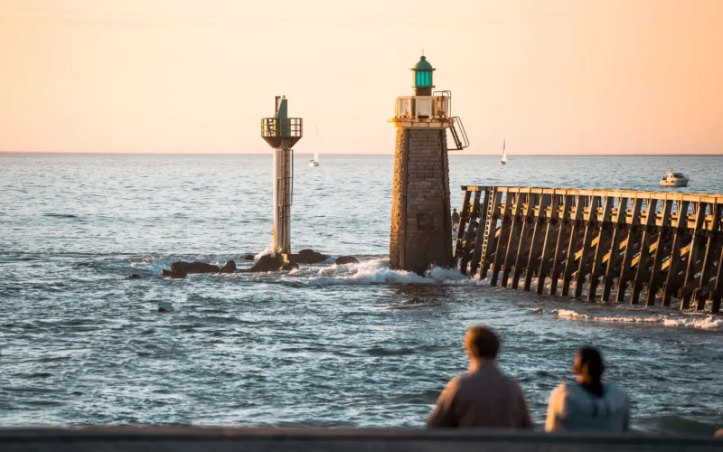 Un couple contemple l'Estacade de Capbreton en fin de journée