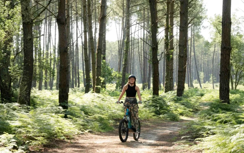 Une jeune femme fait de la trottinette électrique dans les chemins landais